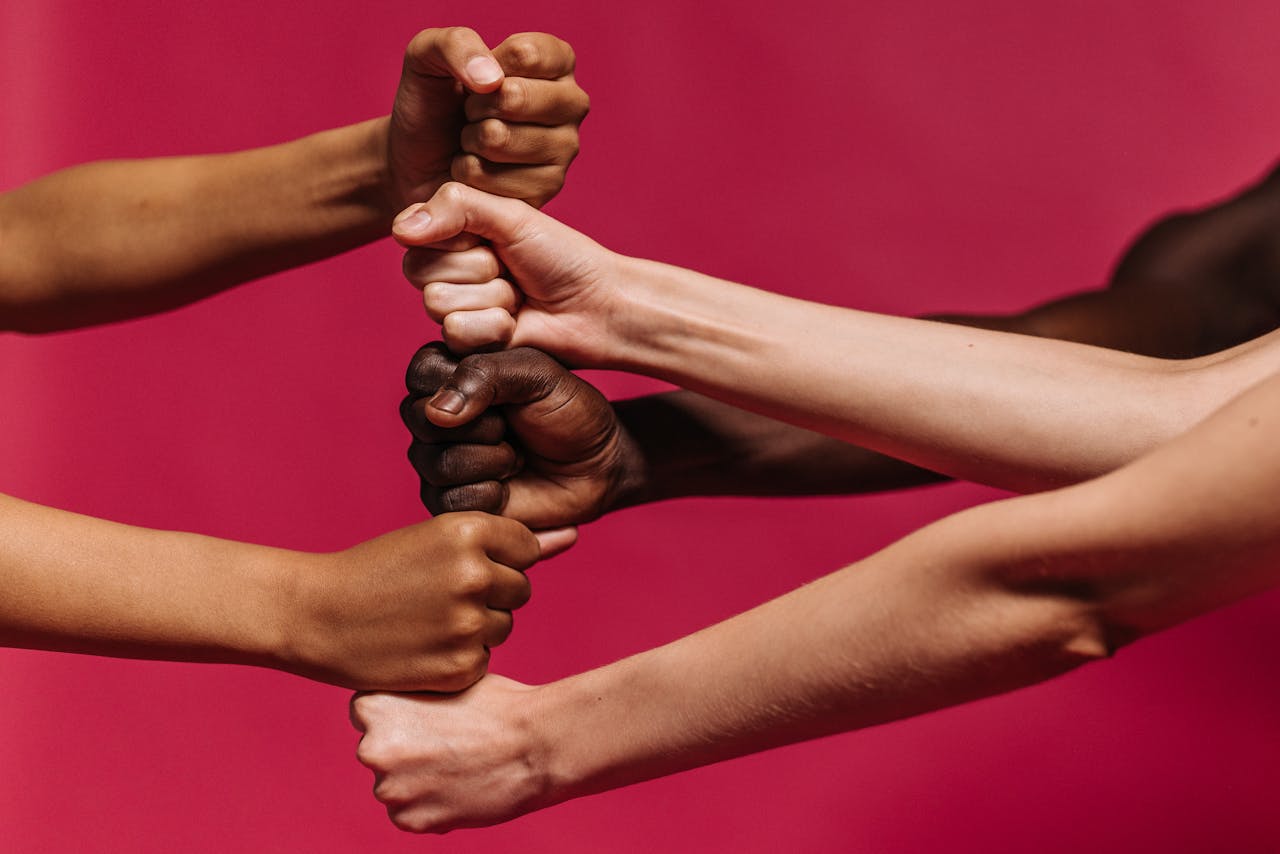 Close-up of diverse hands coming together symbolizing unity and strength.